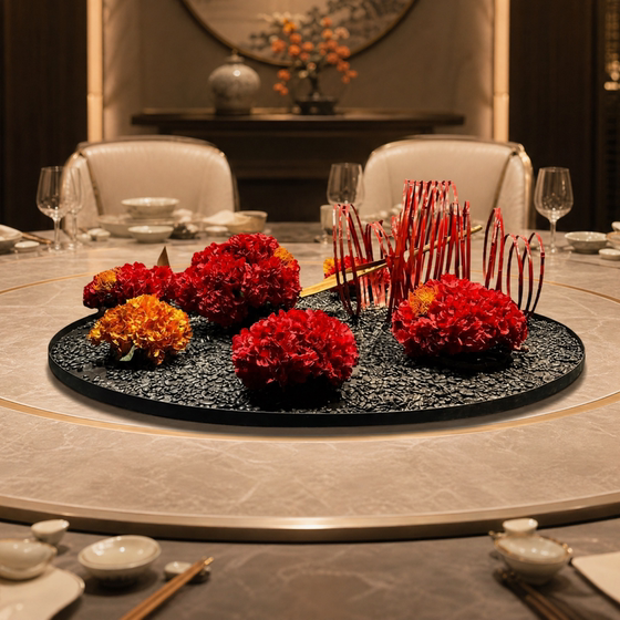 Large round table with turntable and flowers in the middle of the dining table
