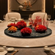Large round table with turntable and flowers in the middle of the dining table