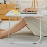 Небольшой стол на кровати, складной столик для складного стола в бурном окне.