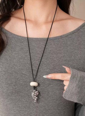 Casual style sweater with chain necklace and fringed pendant