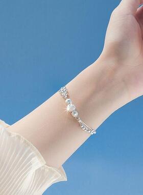 More than three layers of silver-plated bracelets, and a lit