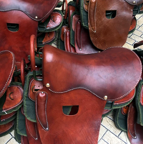 Вся ретро и практическая обстановка седла, демонстрируя декоративный набор украшений и табуреток, овощной загорелой кожи