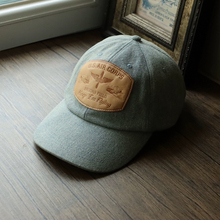 Washed denim paired with Horween horse leather hat, featuring a themed baseball cap featuring aerial combat heroes