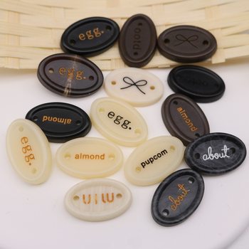65 Types of In-Stock Imitation Horn Resin Trademark Tags, Letter Oval Bow Clothing Labels, High-End Versatile Decorative Buttons
