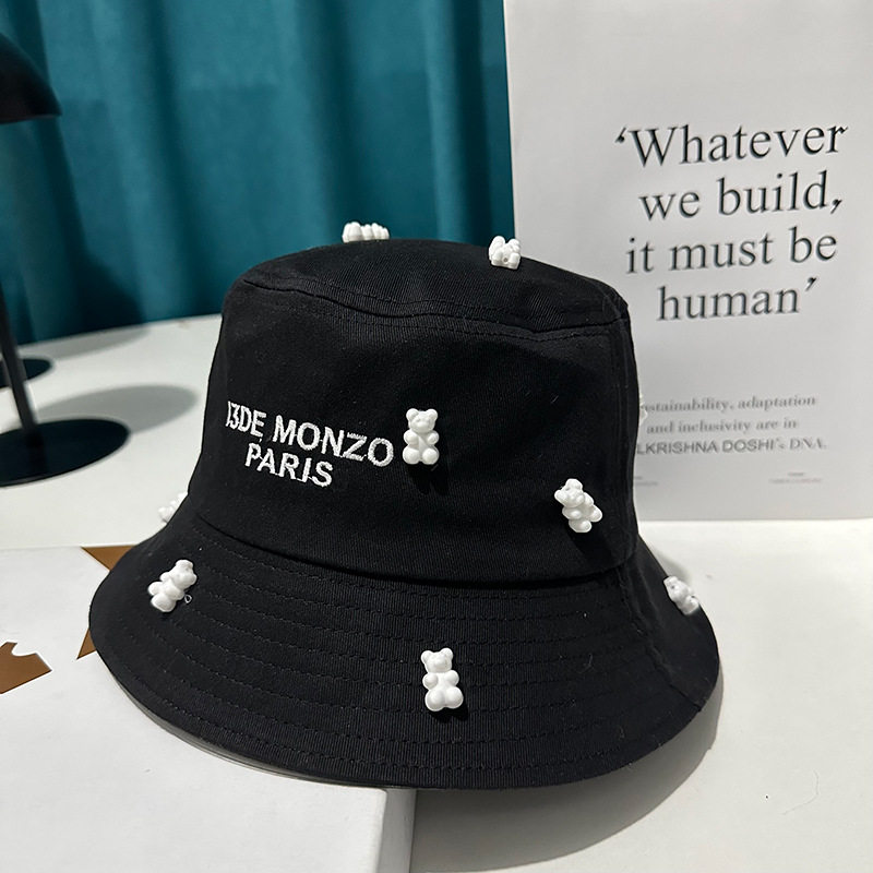 黒い漁師の帽子と白い樹脂の熊