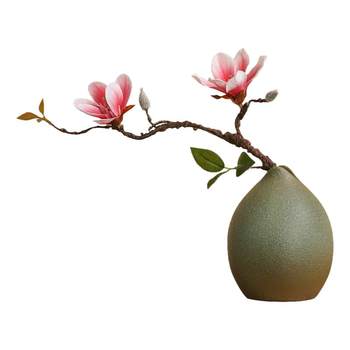 Ceramic vase with green plants and artificial flowers