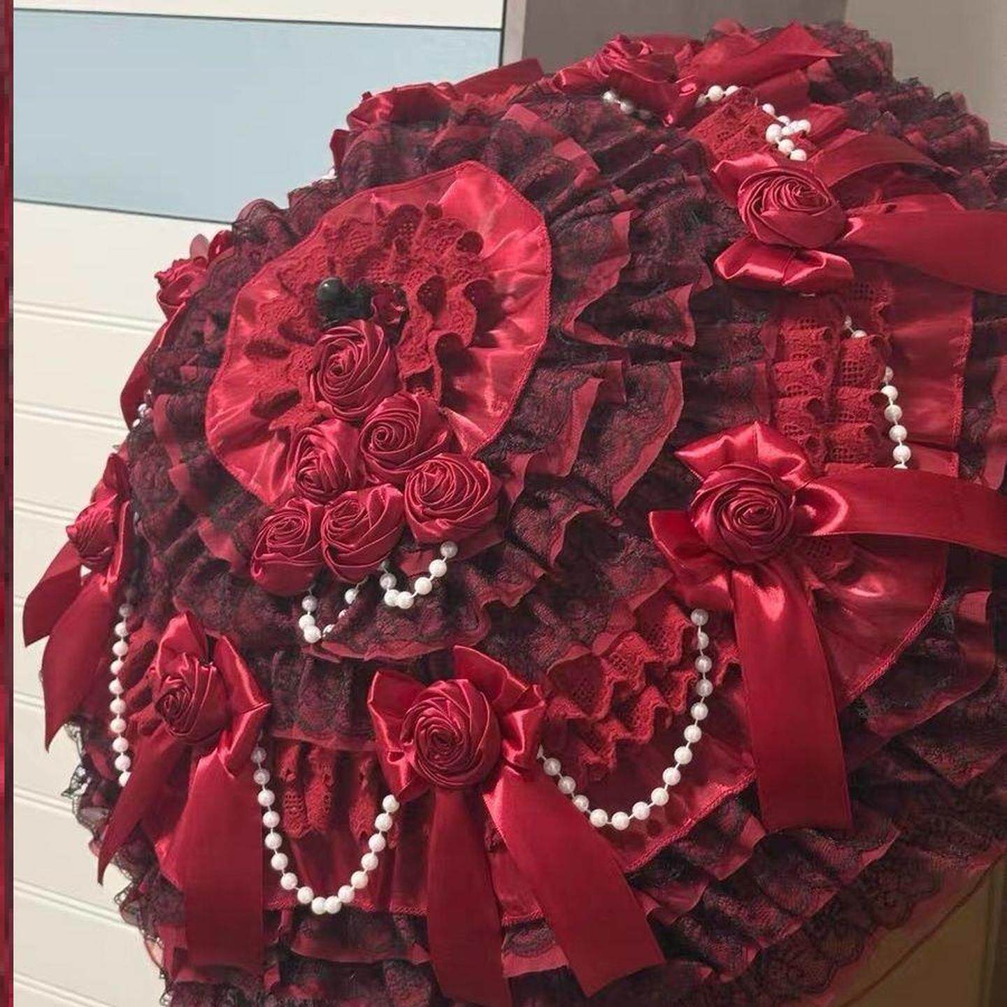 Handmade Lolita accessories: burgundy rose-trimmed parasol with lace pattern, bow, and pearls.