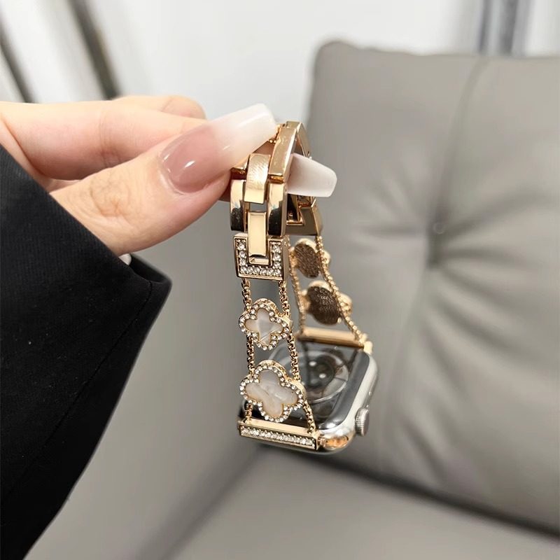 Apple Watch band with a sophisticated summer feel, featuring a metal four-leaf clover design and delicate diamonds, suitable for women.