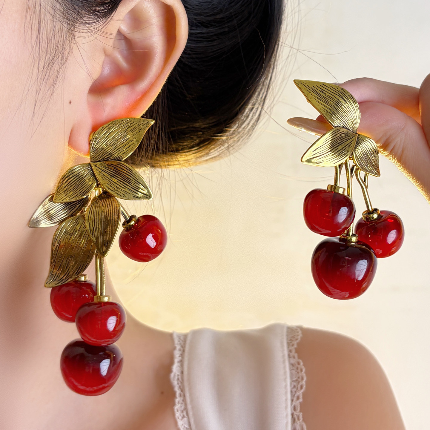 Exaggerated asymmetrical red cherry long earrings for women, vintage style, distressed metal leaf design, high-end feel.