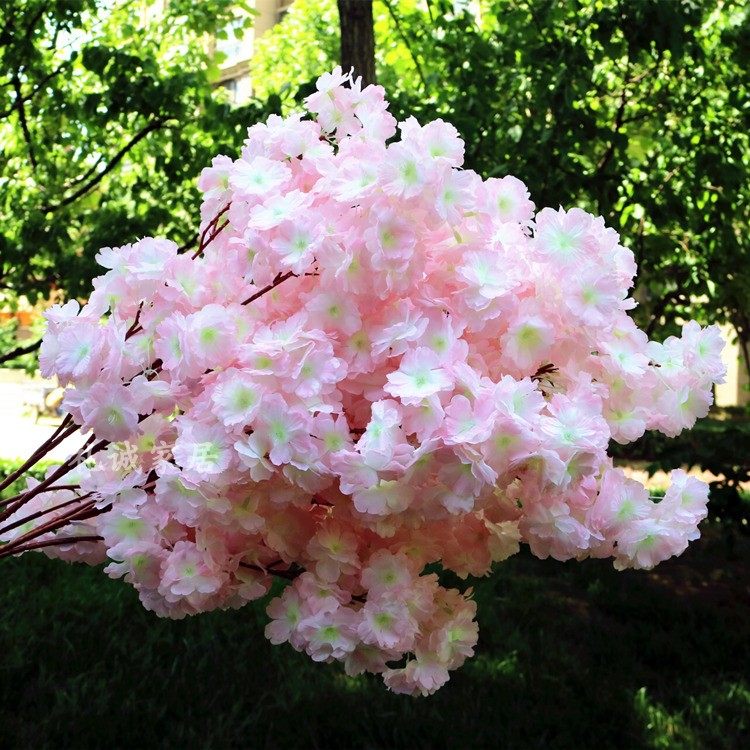 Simulated cherry blossoms ceiling decorated with winding flowers and wedding scenery arches hang walls