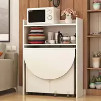 Большой круглый обеденный стол высотой 1,2 м с боковым шкафчиком шириной 65 см белого цвета.