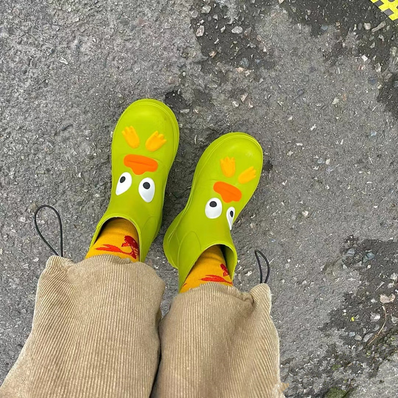 A piece of candy red with green boots in the same butter fruit and green boots in summer fashion wearing water shoes big boots