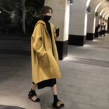 Пальто нового стиля 2025 года с высоким воротником и длинным свитером выше колена с черным трикотажным платьем под ним для осенних и зимних женщин.