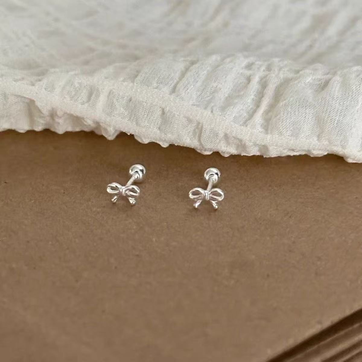 Дизайн ногтей S925 silver bow screw ear bone - это изысканный, компактный и простой дизайн, высококачественные проколотые уши, которые не нужно снимать во время сна.