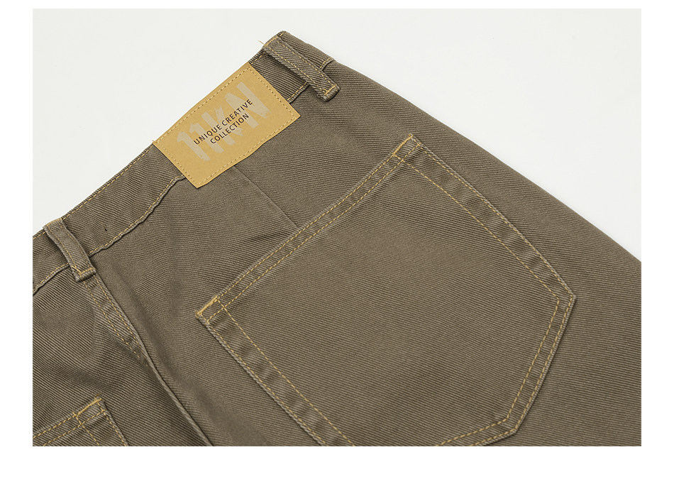 Close-up of the back of EastLyst's Retro Distressed Flare Pants from the 2025 summer collection, showing a single back pocket, tan leather patch label by the waistband, and detailed stitching and fabric texture.