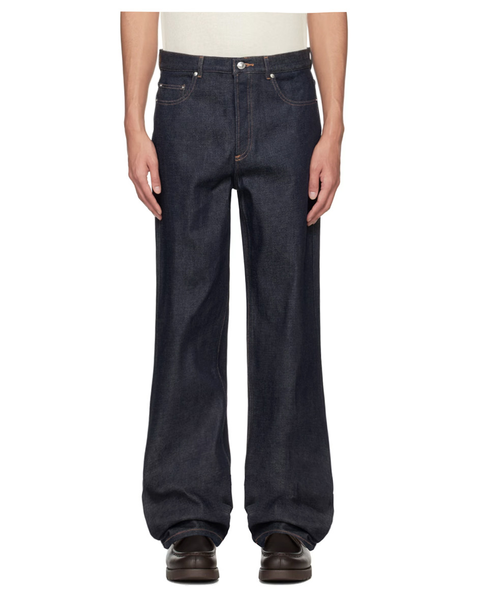 A person wearing EastLyst’s Classic American Straight Leg Jeans—dark blue, relaxed fit with traditional five-pocket styling—paired with a tucked-in white shirt and black shoes, stands against a plain white background.