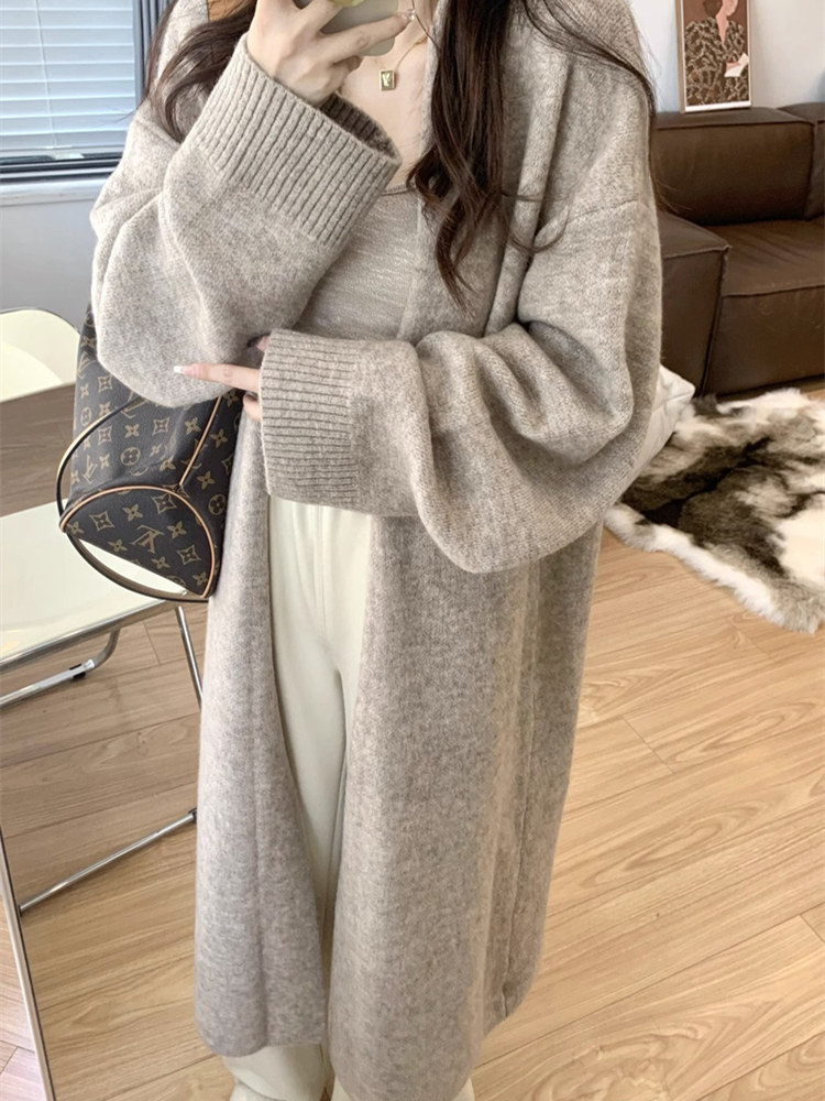 女性向けの、ゆったりとして心地よいミドル丈のニットカーディガン。秋冬にぴったりの、高級感のある膝上丈セーターコート。軽やかなラグジュアリー感を演出する、社交界の女性にふさわしいスタイルです。