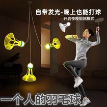 A person plays badminton alone. The training equipment automatically rebounds and plays by himself. The indoor gyration is luminous and luminous.