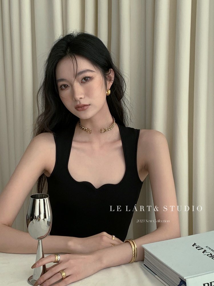 Black sleeveless fitted top worn by a model