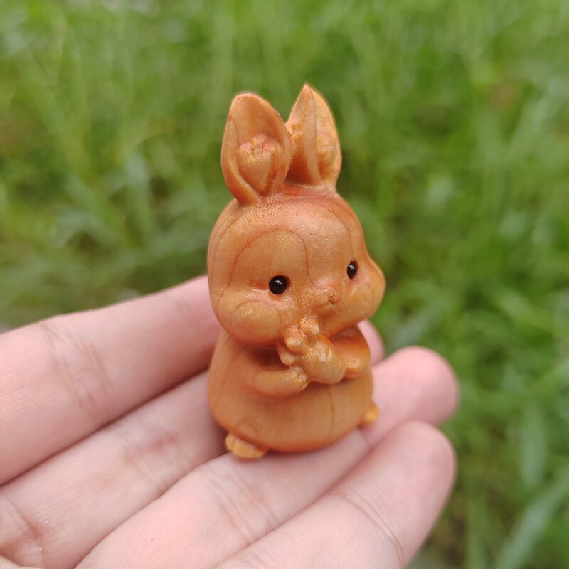 Кролик из редьки Ябай Q Mengwen играет с ручной самодельной простой ветряной тарелкой, играя с китайскими орнаментами ручной работы, вырезанными по дереву