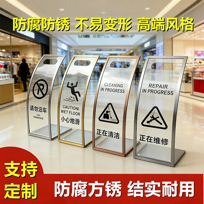 湾曲したアクリル製の「注意：床が滑りやすい」標識／ステンレス製の標識は修理中です。アクリルの洗浄とメンテナンス作業を進めています。