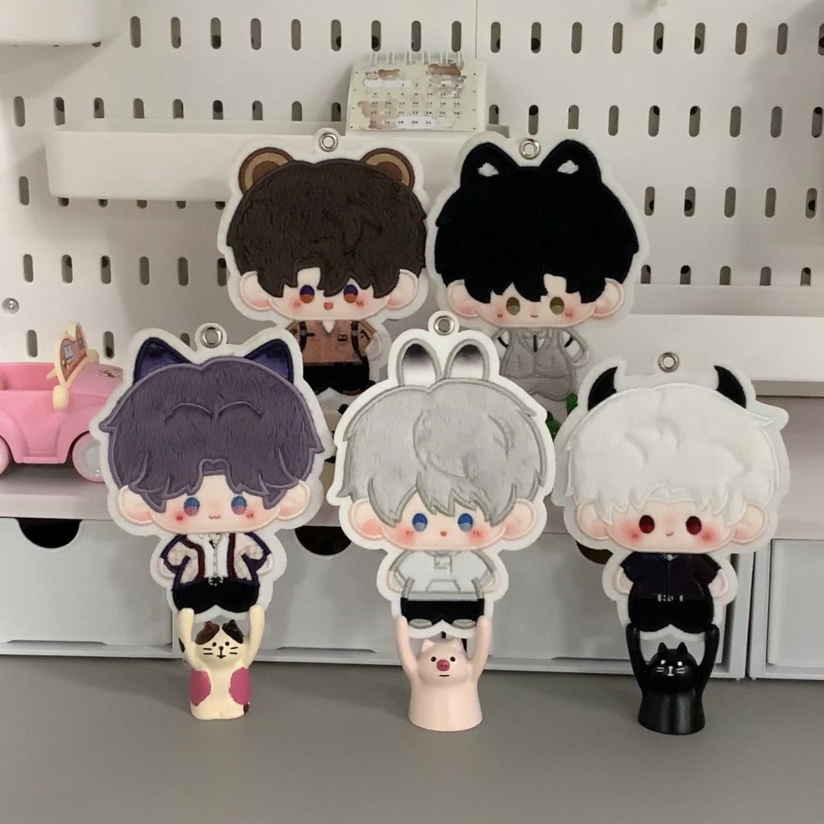 Five animal-ear Love and Deepspace plush charms on a shelf