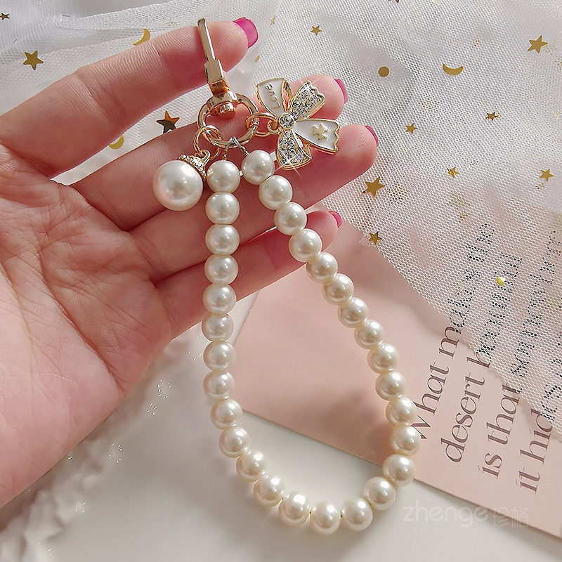 Mobile Phone Lanyard with Rhinestone Bow and Pearl Bracelet for Women ins Simple and Fashionable Chanel-Style Handmade Beaded Chain New Handcrafted Wrist Accessory Clip Spacer Universal Phone Case Strap