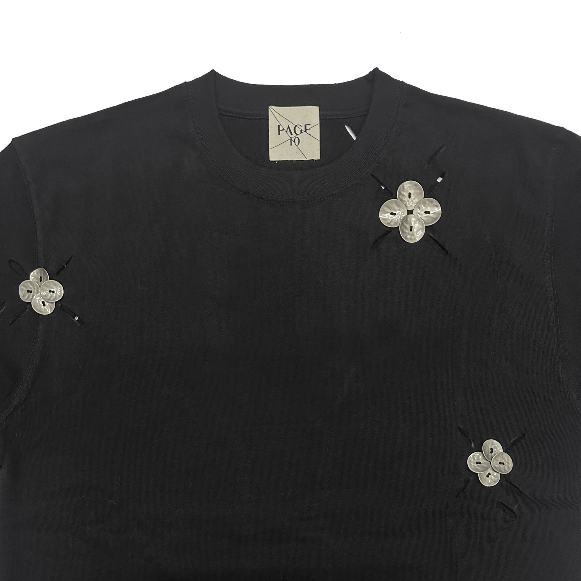 PAGE10 穴あきリーフ柄、メタルの花びらの組み合わせ、重厚な小さめのネックライン、ストレートショルダー、ややゆったりとしたコットンの半袖Tシャツ