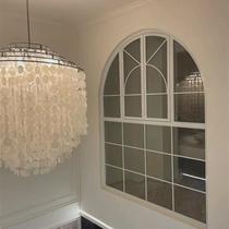 French iron arched floor-to-ceiling windows on the second floor of the loft apartment. Lighting glass art casement windows on the loft duplex building.