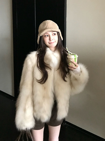 Woman modeling a fluffy cream coat with a matching winter hat