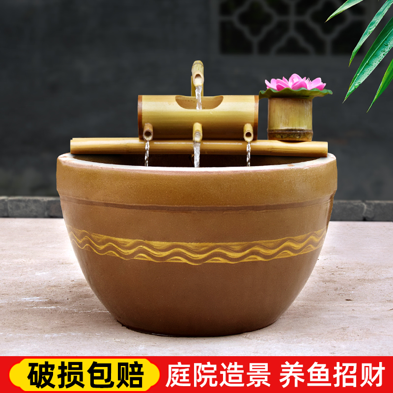 A large old - fashioned tank earthenware water lily cylinder garden plant landscape is suing fish turtles goldfish lotus home