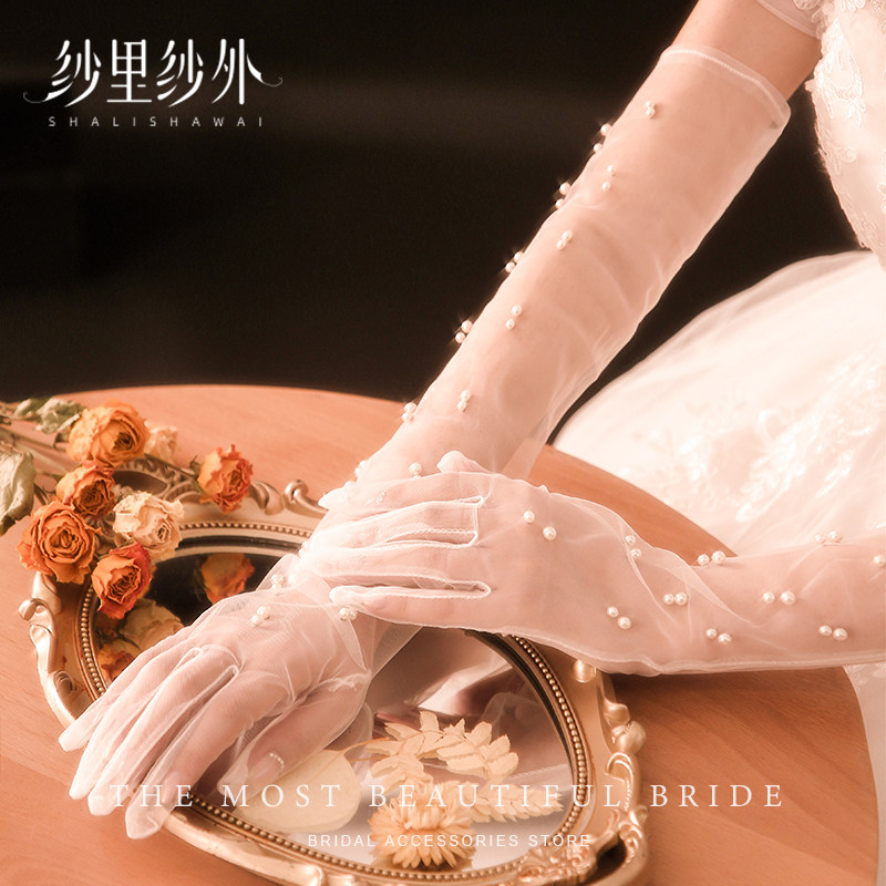 High-end bridal gloves, made of pearl, lace, and mesh, long and exquisitely crafted, covering the arms.