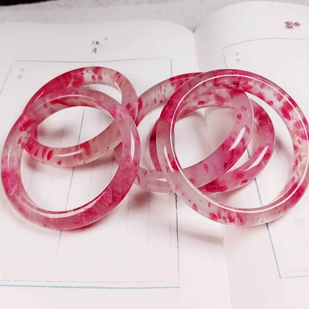 複数の画像が描かれたアイテム1点：氷のような質感の高品質な白く半透明のバングル／バングル。桜やバラの花びらなど、浮かぶような花柄模様が施されています。