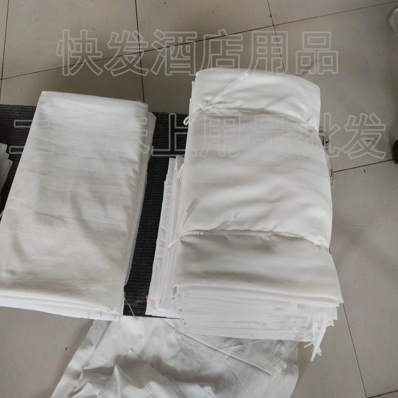 Bộ đồ giường khách sạn đã qua sử dụng được phủ bằng vải cotton trắng tinh khiết.