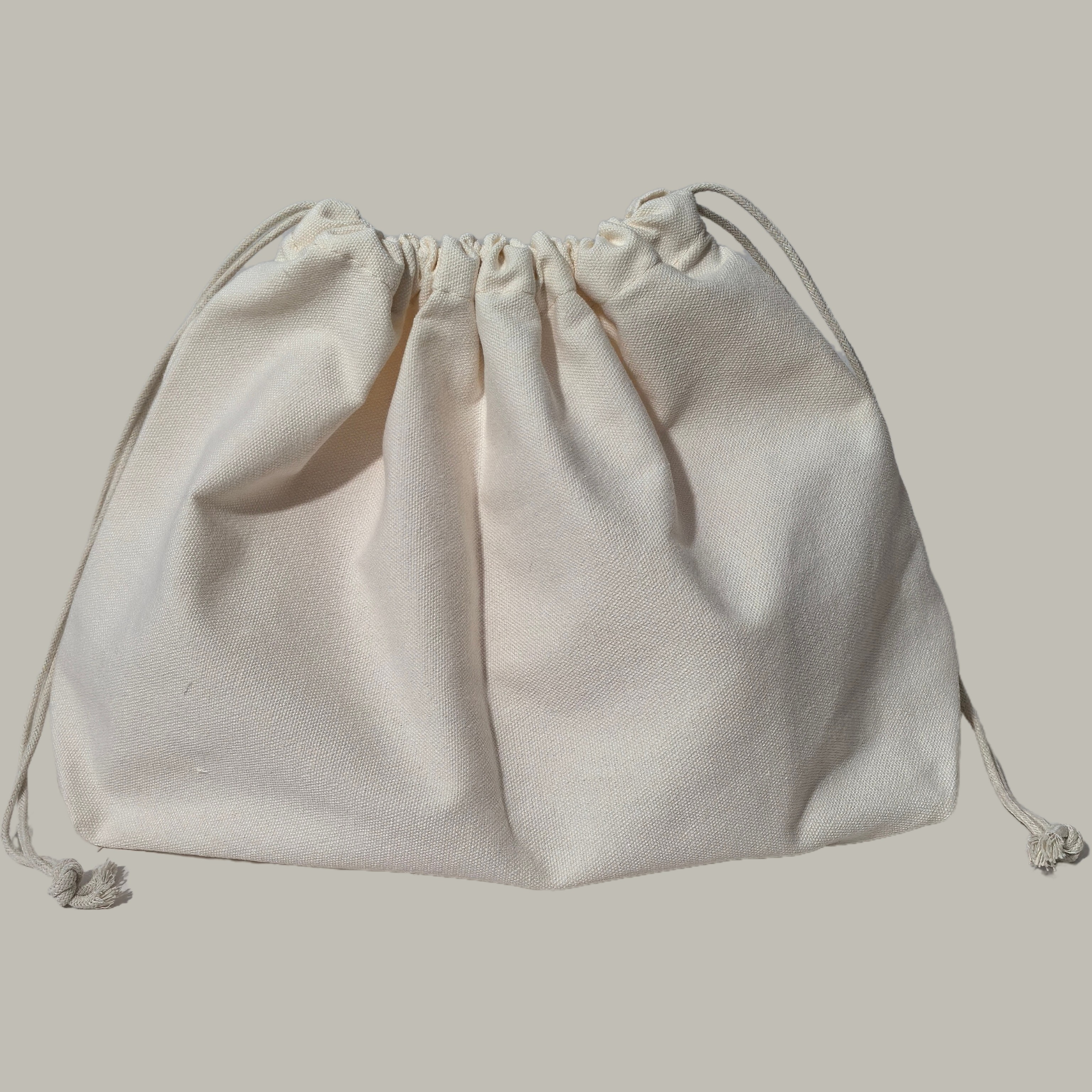 大・中・小サイズの無地キャンバス製収納バッグ。底が四角く、二重の巾着式で、内ポケットと大容量の裏地付き。