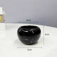 Маленькая круглая фарфоровая раковина черного цвета.