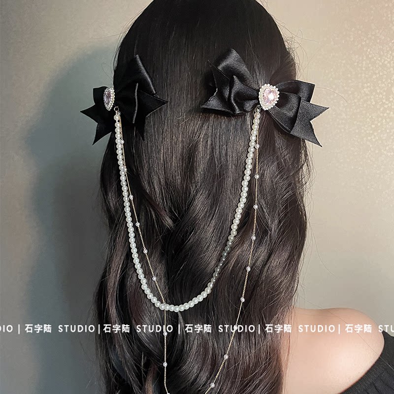 Black bow chain hair clip with heart-shaped rhinestone tassels, a popular style hair accessory. Also includes a suspender strap and side clip.