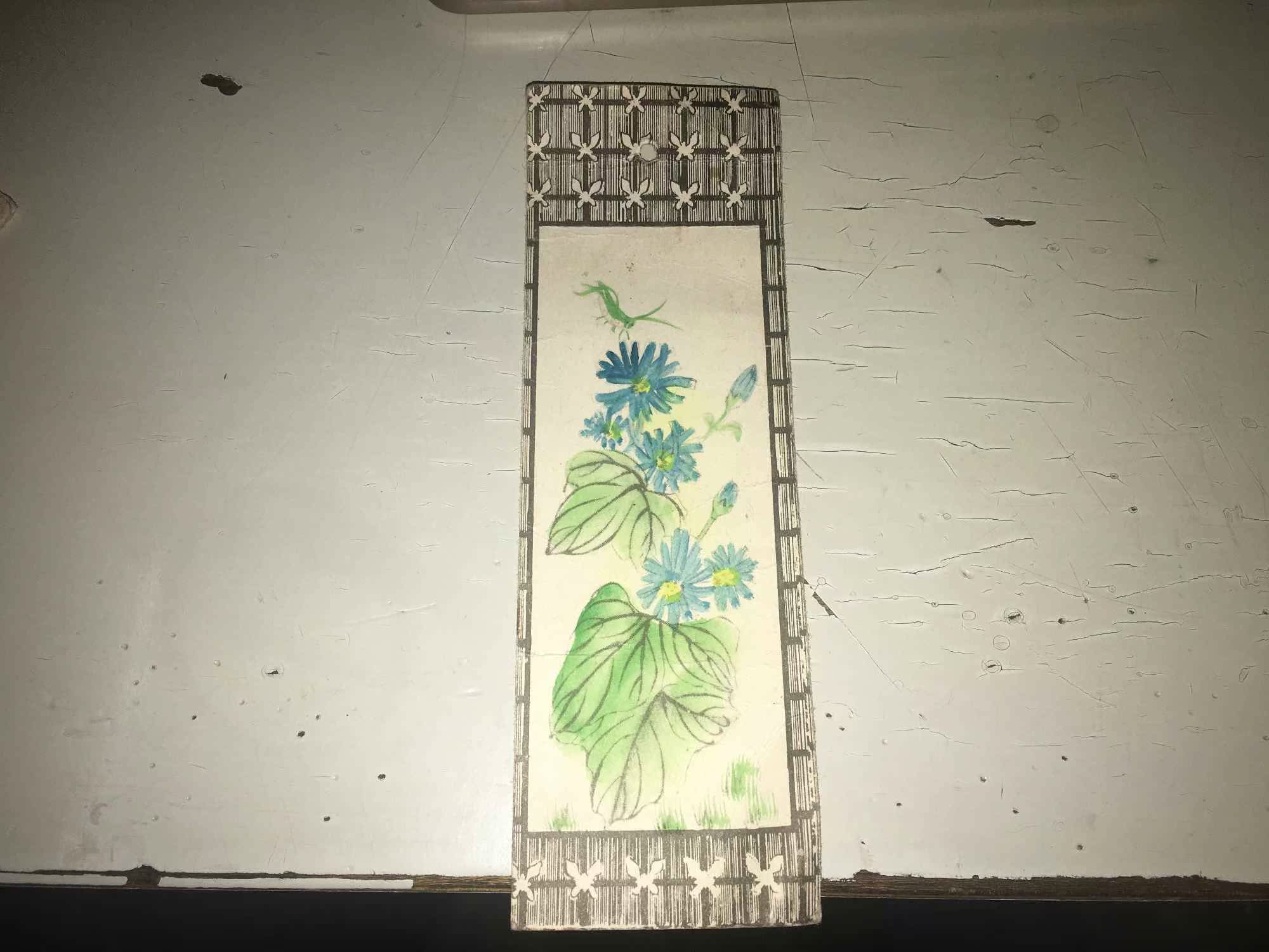 An old bookmark with a Chinese painting of flowers and insects with the school stamp on the reverse