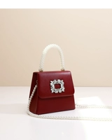 Квадратная пряжка бордового цвета дополнена длинной жемчужной цепочкой.