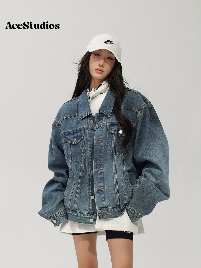 Model wearing an oversized blue denim jacket with a white baseball cap.