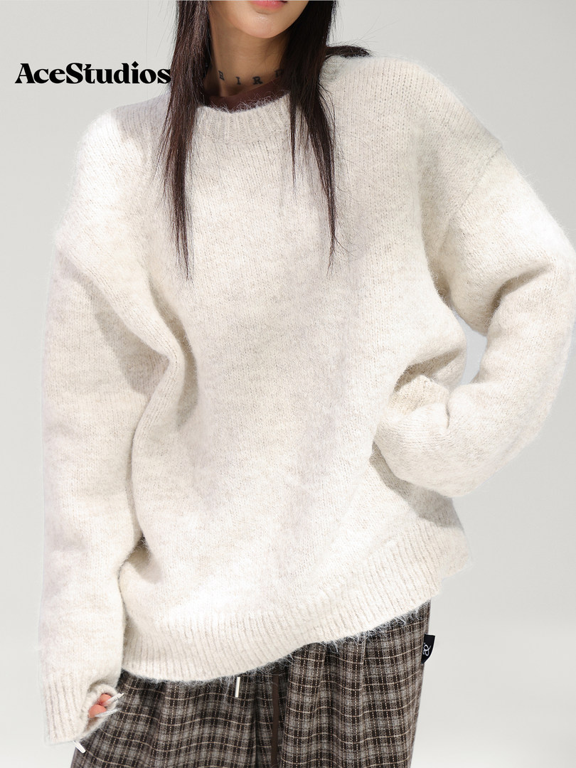 Model wearing an oversized cream knit sweater with plaid pants