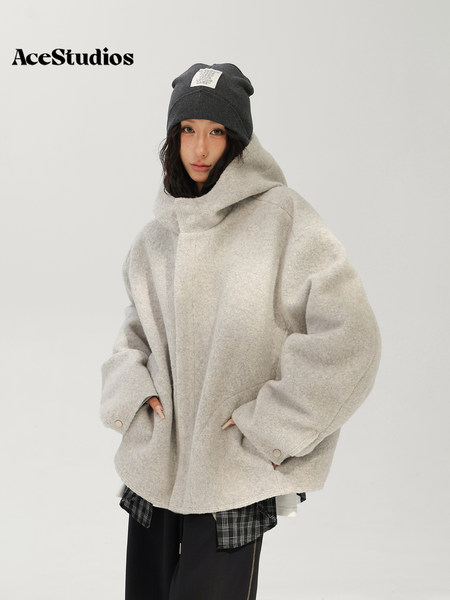 Model wearing a cozy oversized beige fleece hooded jacket with a black beanie.
