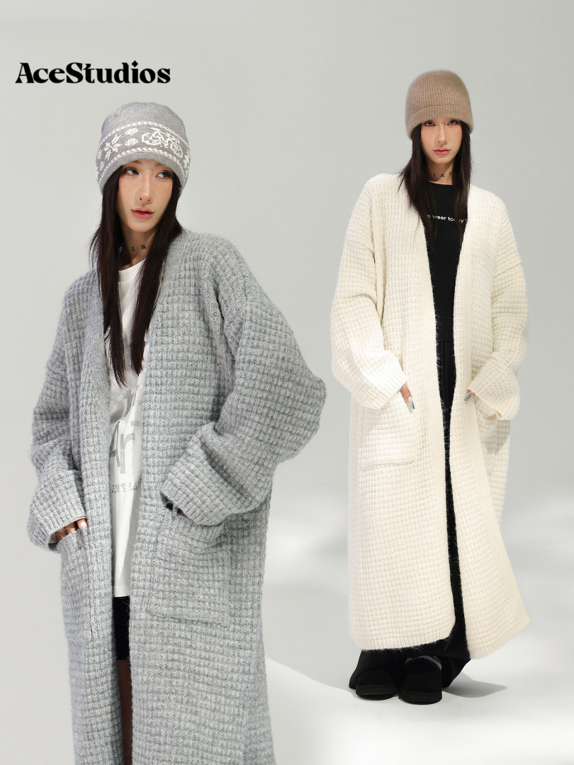 Two models wearing long knitted cardigans and winter beanies