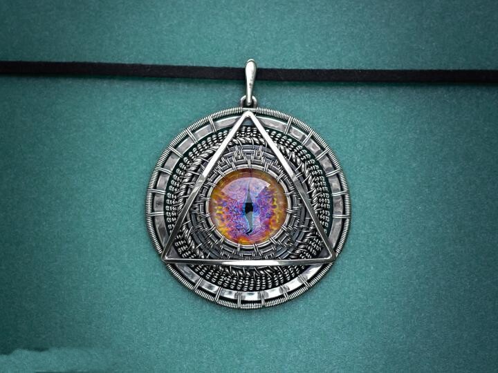 The Belarusian Dragon is handmade gothic silver wire braided around a cabochon longan pendant necklace