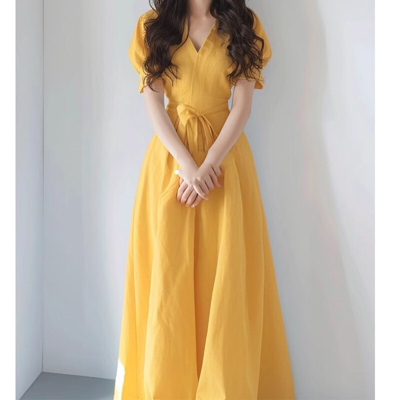 Mango Yellow Dress with a Waist-Cinching Design That Slims the Figure, Featuring a V-Neck in Yellow Cotton and Linen, with a Unique French-Style Design Mango Yellow Dress with a Waist-Cinching Design That Slims the Figure, Featuring a V-Neck in Yellow Cotton and Linen, with a Unique French-Style Design