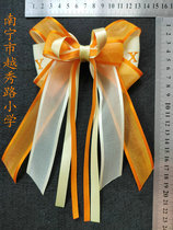 Nanning Yuexiu Xianhu School primary school uniform wearing orange and white bow hair accessories headdress head flower