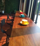 Американский железный сплошной древесина. Домохозяйственное столик, стул в молочный чайный магазин против стены на столе настольной столешницы с высоким содержанием стола и стула