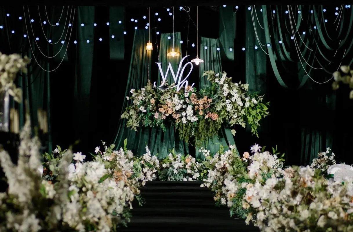 Luxurious emerald green, gold, and cream wedding décor with lush florals and elegant table settings