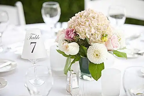 Selection of curated wedding products such as linens, candle holders, and frames arranged on a table
