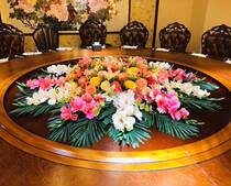 The table is set at the green hotel table The big round table is set to set up flowers and dried flowers to decorate fake flowers